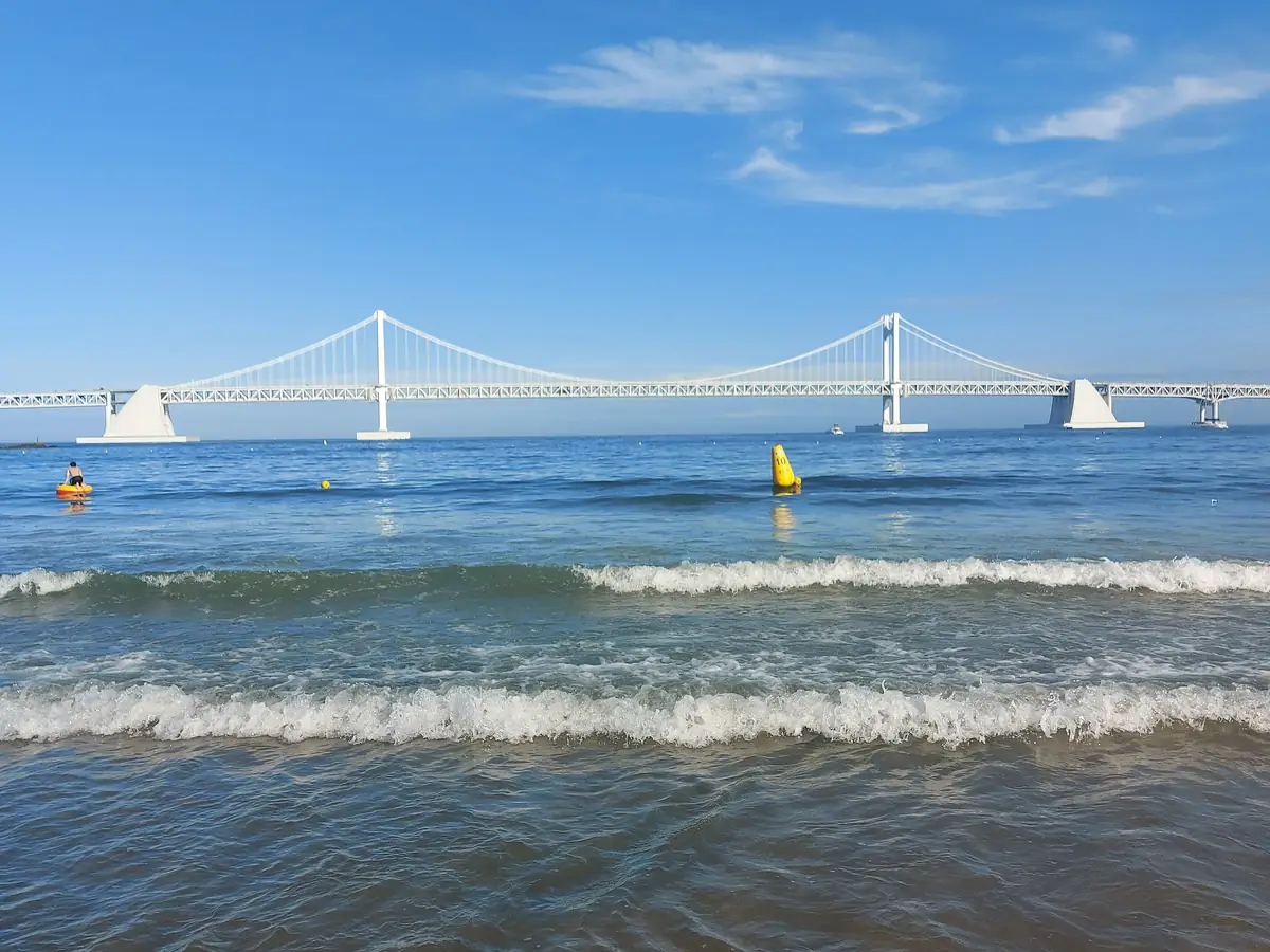Waves on Gwangalli Beach with the Gwangan Bridge across the bay in Busan