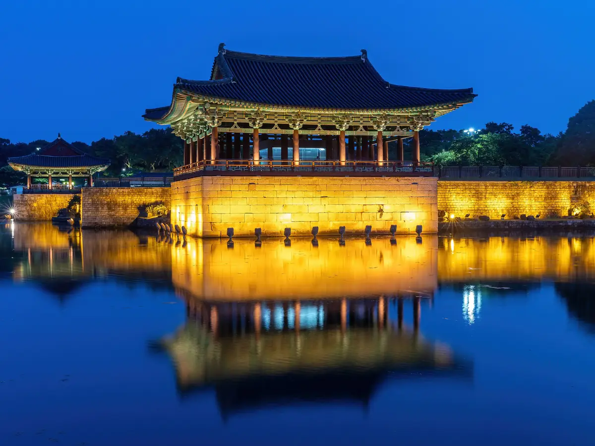 Illuminated Donggung Palace reflected in Wolji Pond at dusk in Gyeongju